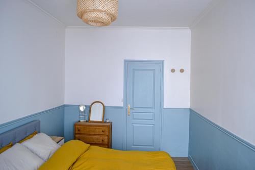 - une chambre bleue avec un lit et une porte dans l'établissement Résidence Caladoise - Rue Centrale, à Villefranche-sur-Saône