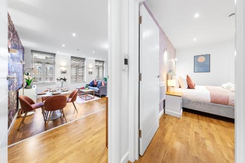 um quarto e sala de estar com uma cama e uma mesa em Modern One Bedroom Flat - Near Heathrow, Windsor Castle, Thorpe Park - Staines London TW18 em Staines upon Thames