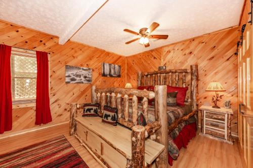 um quarto com uma cama de madeira e uma ventoinha de tecto em Hook, Line and Sinker Cabin features firepit and hot tub! em Sevierville