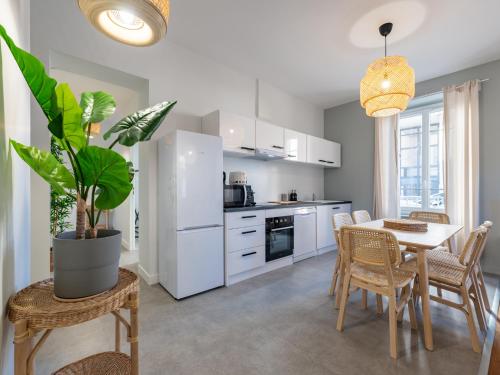 a kitchen and dining room with a table and chairs at Le cocon urbain T3, 6 personnes, avec parking proche TRAM ET METRO in Villeurbanne