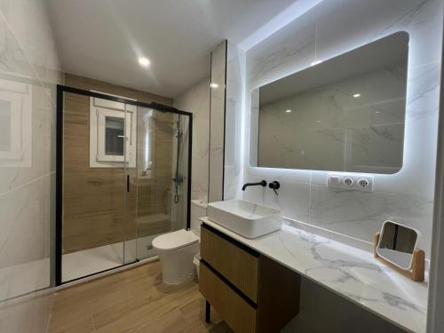 y baño con lavabo, aseo y espejo. en The Traveller`s house con vistas a PLAYA LA CALETA, en Cádiz
