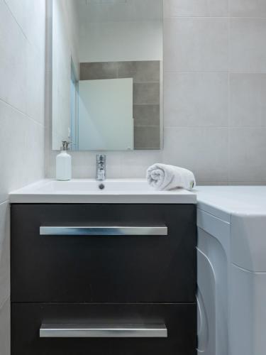 une salle de bain avec un lavabo et un miroir dans l'établissement Le cocon urbain Maison, 6 personnes, avec parking proche TRAM ET METRO, à Villeurbanne