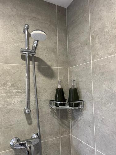a shower with two green bottles on a tile wall at A brand new apartment in Pieta