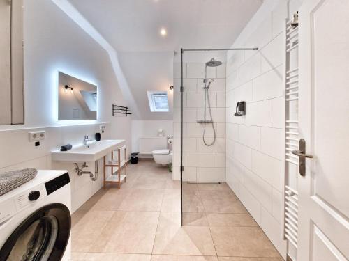 a bathroom with a shower and a sink and a washing machine at Altstadt-Ferienwohnungen Braunschweig in Braunschweig