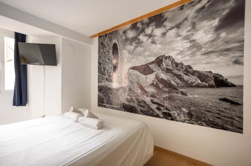 a bedroom with a large painting on the wall at Apartamentos Bermeo, Museoa in Bermeo