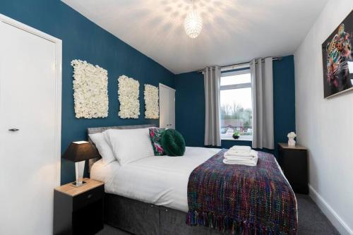 1 dormitorio con cama y pared azul en Town centre & all the comforts!, en Guisborough