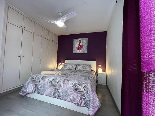 a bedroom with a bed and a purple wall at Casa La Laguna in La Laguna