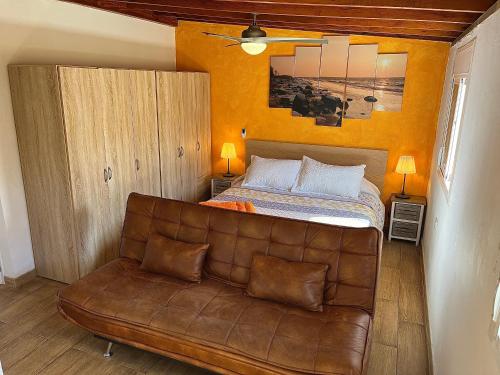 a bedroom with a bed and a leather couch at Casa La Laguna in La Laguna