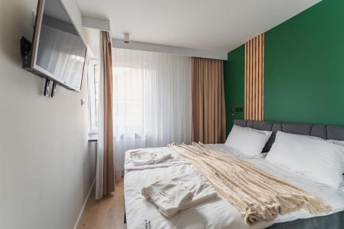 um quarto com uma cama com uma parede verde em Apartament FoRest - widok na Śnieżkę, Sauna IR, parking podziemny em Karpacz