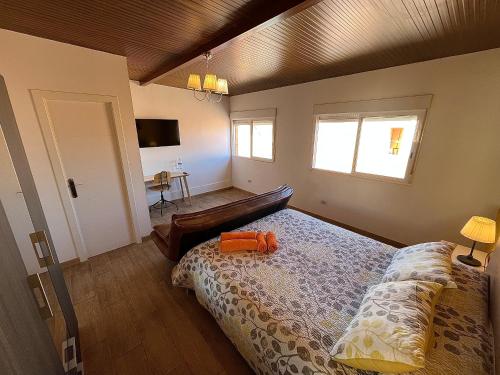 a bedroom with a bed with an orange pillow on it at Casa La Laguna in La Laguna