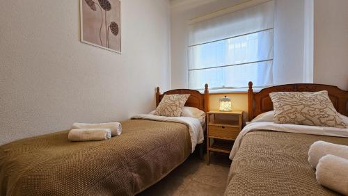 1 dormitorio con 2 camas y ventana en TERRAMAR sweet home en Villajoyosa