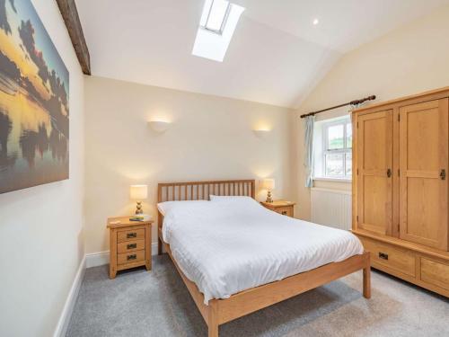 a bedroom with a bed and two night stands and a window at 3 Bed in Longhoughton 88231 in Long Houghton