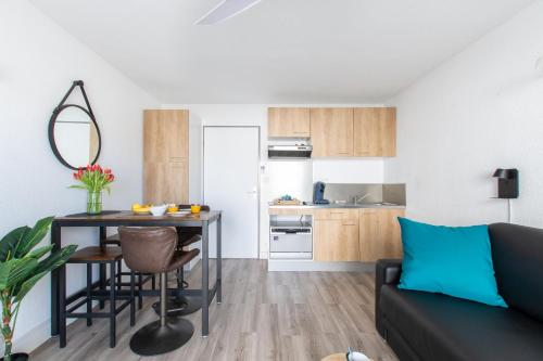 Il comprend un salon et une cuisine avec une table et un canapé. dans l'établissement L'Éden des Vacances * clim * Terrasse * wifi *Port, à La Grande Motte