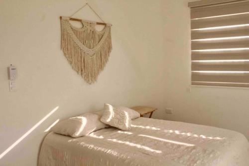 um quarto com uma cama com duas almofadas em Departamento mar y arena em Chicxulub