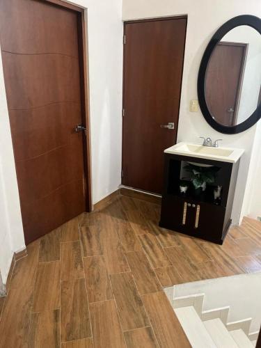 La salle de bains est pourvue d'un lavabo, d'un miroir et d'une porte. dans l'établissement CASA FAMILIAR, à San Antonio de la Cal