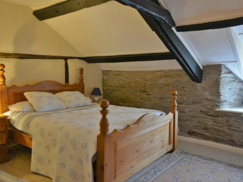 sypialnia z drewnianym łóżkiem w pokoju w obiekcie 3 Bed in Boscastle 75145 w mieście Boscastle