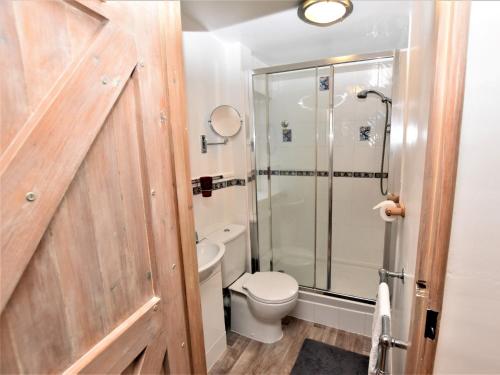 a bathroom with a toilet and a glass shower at 3 Bed in Ilfracombe 66239 in Ilfracombe