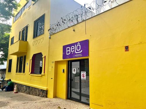 a yellow building with a sign on the side of it at Belô Hostel in Belo Horizonte