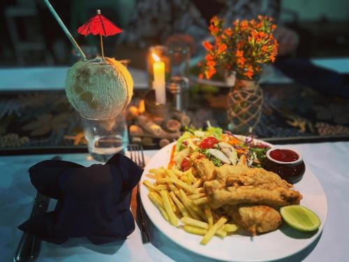 a plate of food with chicken and french fries on a table at Tanna Evergreen Resort & Tours in Tanna Island