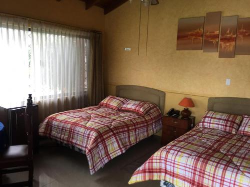 1 dormitorio con 2 camas y ventana en CASTILLO DEL VALLE, en Quito