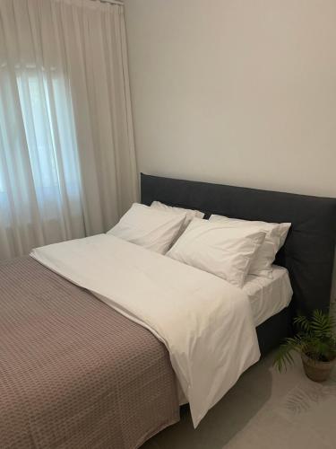 a bed with white sheets and pillows in a bedroom at Ground Zero Appartment in Thessaloniki