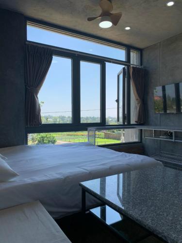 a bedroom with a bed and a large window at miniHomestay green view & warm pool - all apartment - 3 room - 6 persons - Ea Kar - Dak Lak in Buôn Mhang