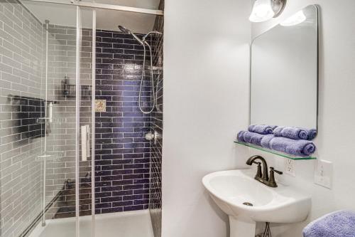 a bathroom with a sink and a glass shower at Eclectic Stone Cottage, Walk to Downtown Staunton! in Staunton