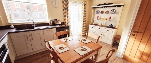 a kitchen with a wooden table and a kitchen with a sink at Manby Fields, Manby in Louth