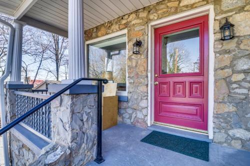 a red door on a house with a stone wall at Eclectic Stone Cottage, Walk to Downtown Staunton! in Staunton