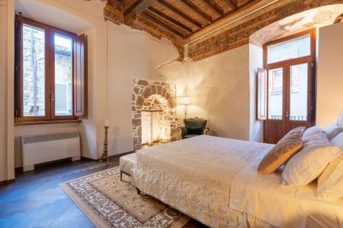1 dormitorio con 1 cama grande y ventanas en centro storico - LUXURY EXPERIENCE NARNI VINTAGE ÉLITE SUITE, en Narni