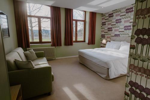 1 dormitorio con 1 cama, 1 sofá y 1 silla en Château de Looz, en Borgloon