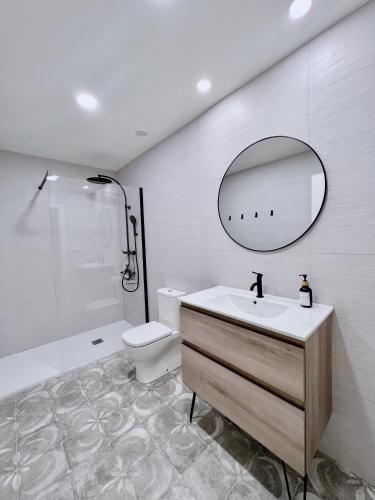 a bathroom with a sink and a toilet and a mirror at Apartamento Domus in Teruel