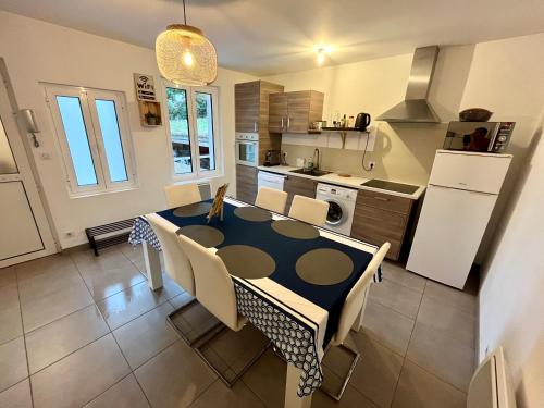une cuisine avec une table et des chaises dans une pièce dans l'établissement Appartement 2 chambres lumineux, à Maisse