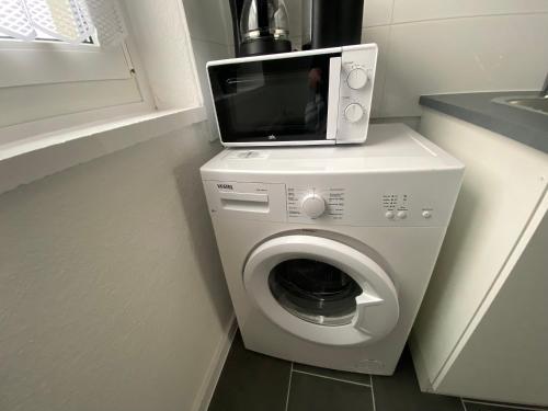 a microwave sitting on top of a washing machine at Wunderschöne neue Ferien und Monteurwohnung THM 17 in Wefensleben