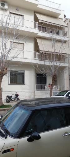 a car parked in a parking lot in front of a building at Yianni's Home-Comfort Apartment in Volos in Volos