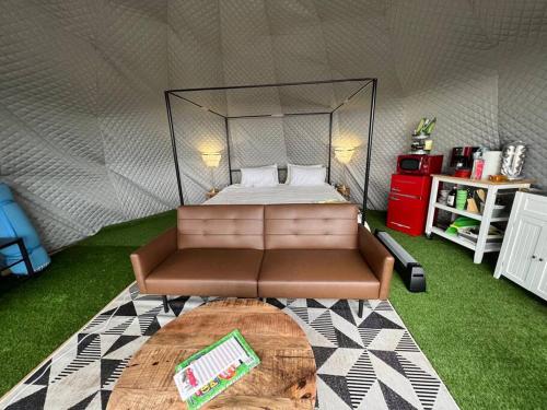 a room with a bed and a couch in a tent at Glamping Dome 1 - 10 minutes from Kings Canyon in Dunlap