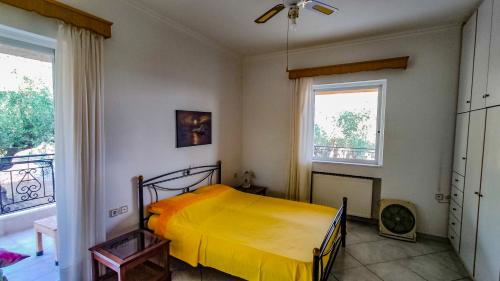 a bedroom with a yellow bed and a window at Your Spot West Peloponnese in Zakharo