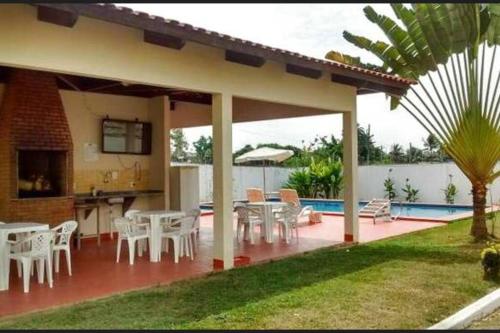 a patio with white tables and chairs next to a pool at Apartamento inteiro em condomínio in Rio Branco