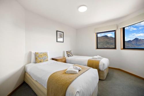 two beds in a room with two windows at Sun-filled on Wakatipu - New Queenstown Listing in Queenstown