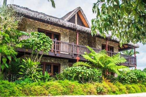 ein Haus mit einem Balkon an der Seite in der Unterkunft Tanna Evergreen Resort & Tours in Insel Tanna