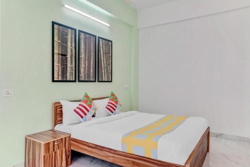 a bedroom with a bed with white sheets and pillows at OYO Home Dazzling Studios Near Airport Near Pune Airport in Lohogaon