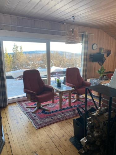 a living room with two chairs and a table at Cabin in the Mountain, Outstanding View & Solar Energy in Slidre