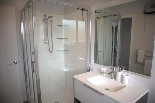 a white bathroom with a sink and a shower at Sunset Views in Kaikoura