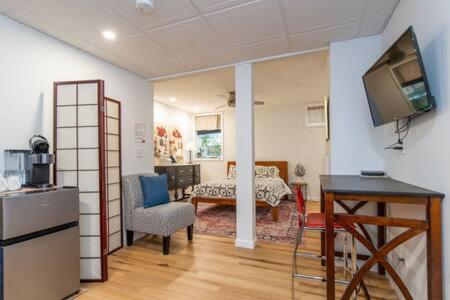 a room with a kitchen and a living room with a television at Cozy Private Apt near Downtown in Burlington