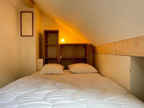 Charmant duplex pour 2/3 pers في كوتيريه: سرير كبير مع وسادتين في غرفة