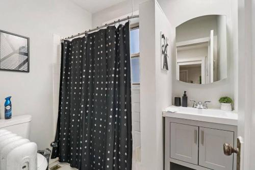 a bathroom with a black shower curtain with white stars at Elegant & Stylishly 1BR Fully Furnished Apt - Lincoln 205 in Chicago