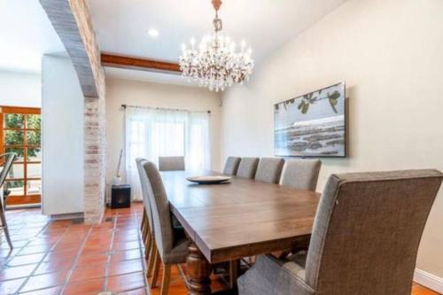 - une salle à manger avec une table et des chaises en bois dans l'établissement The Manhattan Villa, à Los Angeles