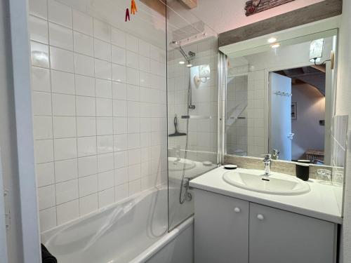 a white bathroom with a sink and a shower at Charmant duplex pour 2/3 pers in Cauterets