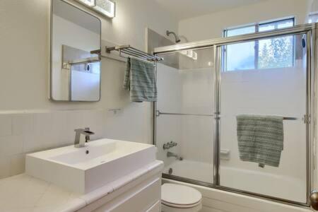 a white bathroom with a sink and a shower at Red Door Cottage Fireplace bbq 12 mi to Yosemite in Oakhurst