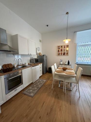 una cucina e una sala da pranzo con tavolo e sedie di Darling Home a Merano